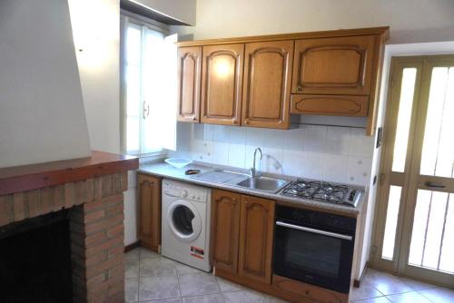 a kitchen with wooden cabinets and a sink and a dishwasher at Eden - Nel Cuore Della Natura in Compignano