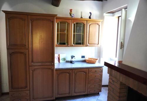 a kitchen with wooden cabinets and a counter at Eden - Nel Cuore Della Natura in Compignano