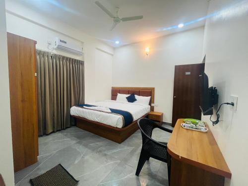 a bedroom with a bed and a desk and a table at Nature Inn With Greenery Comforts in Devanahalli-Bangalore