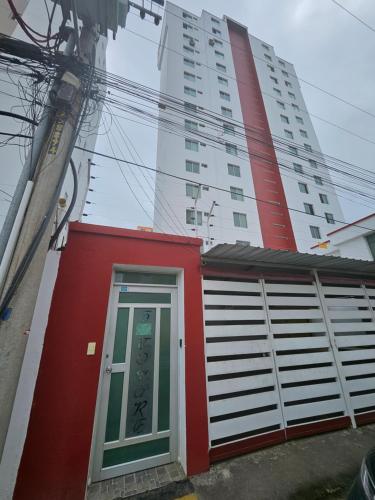 a red building with a door in front of a building at Tonsupa Beach in Tonsupa