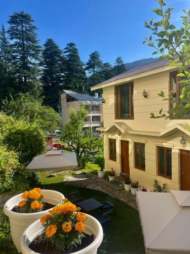 a backyard with two large white pots with flowers at Sparsh Resort, A Boutique Stay - Just 2kms uphill from Mall Road, near Old Manali in Manāli