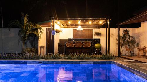 a swimming pool in front of a house at night at Villas y Casa Dìwö - Puerto Viejo in Hone Creek