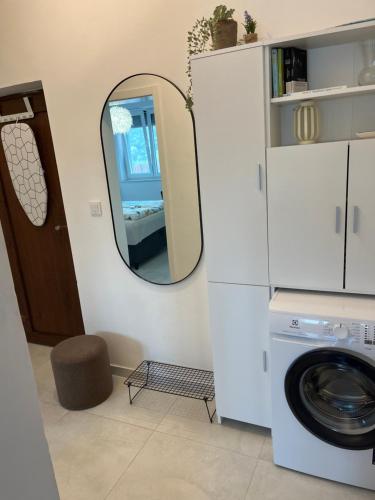 a laundry room with a mirror and a washing machine at M&M tisno in Tisno