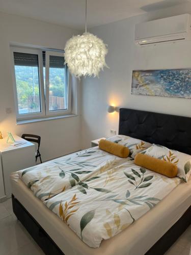 a bedroom with a large bed with a chandelier at M&M tisno in Tisno