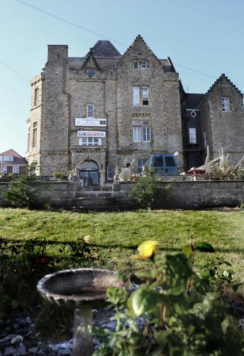 an old stone building with a bird bath in front of it at Highlands Hotel and bar in Hastings
