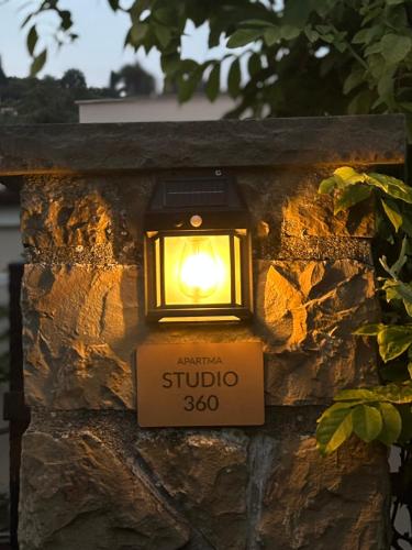 a lantern on a stone wall with a sign on it at Studio 360 in Portorož