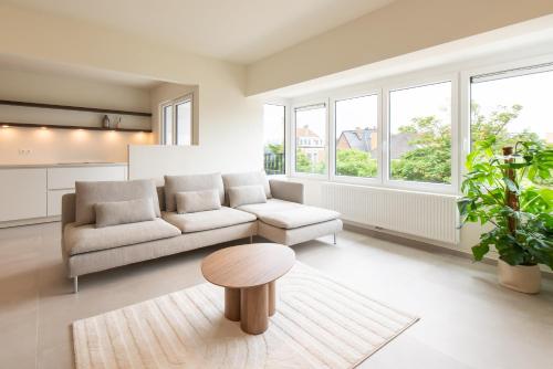 a living room with a couch and a table at Cozy Seaside Apartment in Ostend