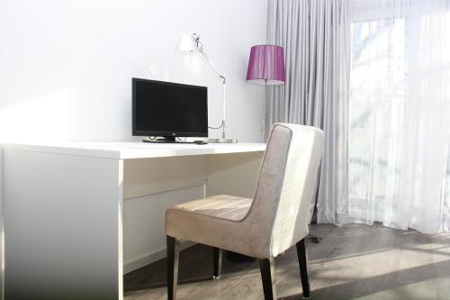 a white desk with a computer monitor and a chair at Victoria Living in Jockgrim