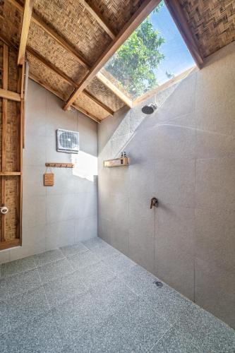 a bathroom with a shower with a skylight at My Island Home Gili Air in Gili Air
