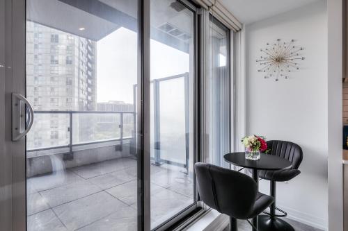 a room with a balcony with a table and chairs at RivetStays - The Jarvis in Toronto