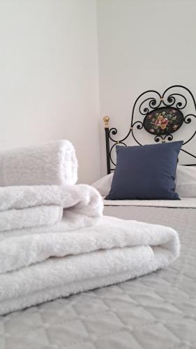 a pile of white towels sitting on a bed at La tappa del vignaiolo Home in Mamoiada