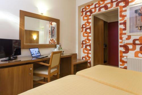 a hotel room with a desk with a laptop and a mirror at Leto Boutique Hotel Agrinio in Agrinion