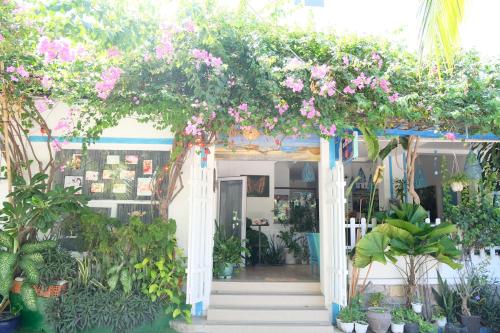 an entrance to a house with flowers and plants at La Marina Boutique Hotel & Spa in Mui Ne