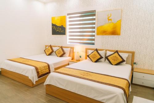 a room with two beds in a room at Bảo Ngọc Hotel in Uông Bí