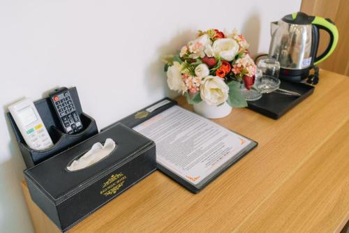 a wooden table with a box and flowers on it at Bảo Ngọc Hotel in Uông Bí