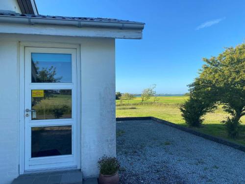 a white door with a view of a field at Light-filled Retreat in Boddum - By Traum Ferienwohnungen in Boddum