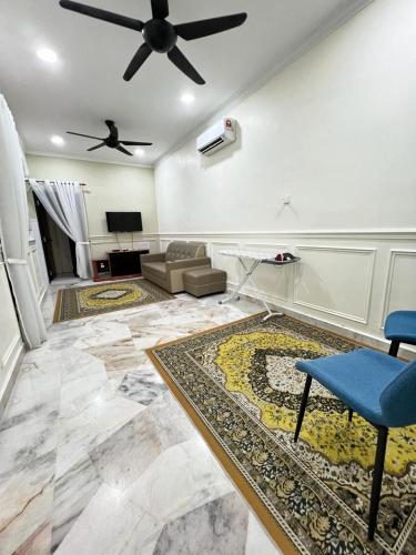 a living room with a ceiling fan and a couch at De Raisha Homestay in Butterworth