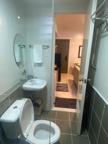 a bathroom with a toilet and a sink at Kral Suite in Las Piñas in Manila
