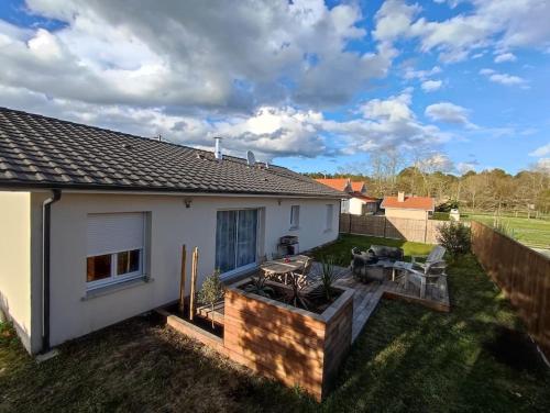 une maison avec une arrière-cour dotée d'une table et de chaises dans l'établissement Maison sur le bassin, à Audenge