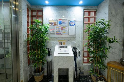 a room with a counter with two potted plants at HOTEL AARON通天東 in Osaka