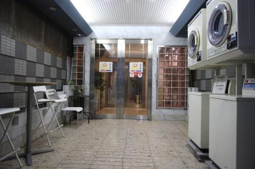 a lobby with a door and chairs in a building at HOTEL AARON通天東 in Osaka