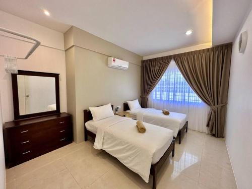 a hotel room with two beds and a mirror at Jk Home Stampin Semi-Detached 12pax 4BedR 3BathR 4Carparks in Kuching