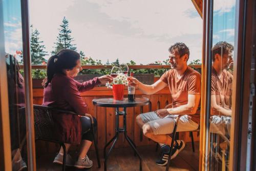 a group of people sitting around a table on a balcony at Wellness Penzion u Michala in Zuberec