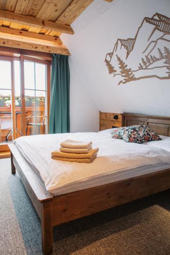 a bedroom with a bed with towels on it at Wellness Penzion u Michala in Zuberec