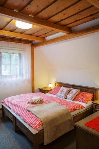 a bedroom with two beds in a room with wooden ceilings at Wellness Penzion u Michala in Zuberec
