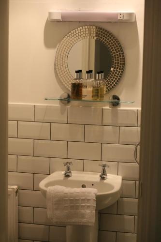 a bathroom with a sink and a mirror at Highlands Hotel and bar in Hastings