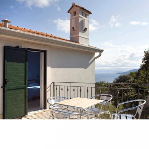 a table and chairs on the balcony of a house at Apartments Villa Ina in Brseč