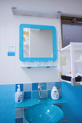 a bathroom with a blue sink and a mirror at HOTEL AARON通天東 in Osaka