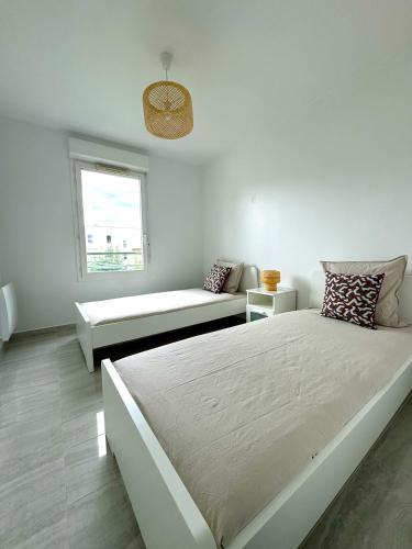 - une chambre blanche avec un grand lit et un banc dans l'établissement Le Havre du Stade de France BY UTA HOUSE, à Saint-Denis