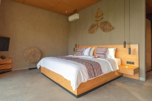 a bedroom with a large bed with a butterfly on the wall at Villa Bula in Umeanyar