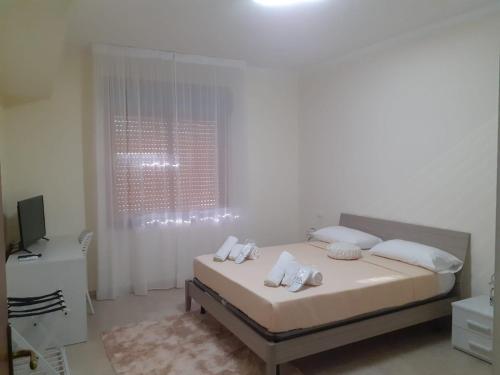 a white bedroom with a bed with white pillows at LOVELY BIANCO - Rooms & Apartment in Bianco