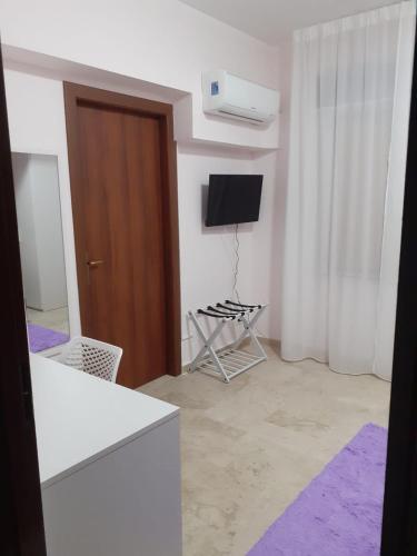 a living room with a television and a chair at LOVELY BIANCO - Rooms & Apartment in Bianco
