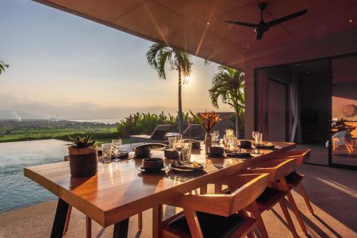 a long wooden table with a view of the ocean at Villa Bula in Umeanyar
