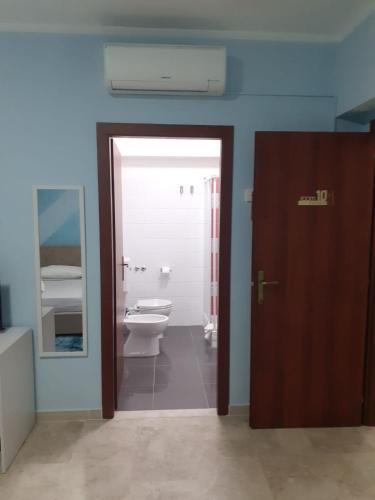 a bathroom with a toilet and a mirror and a door at LOVELY BIANCO - Rooms & Apartment in Bianco