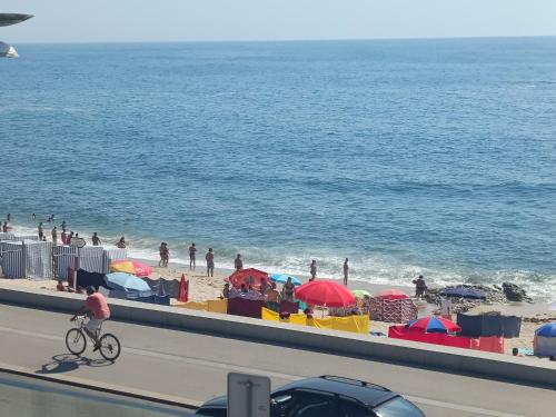 eine Person, die mit Sonnenschirmen an einem Strand Fahrrad fährt in der Unterkunft Cachinnans Hostel & Apartments in Vila do Conde