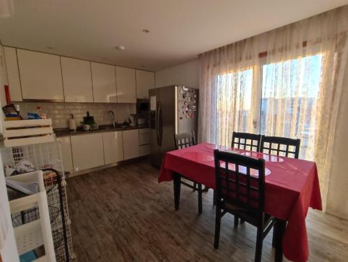 eine Küche mit einem Tisch und einem roten Tischtuch in der Unterkunft Cachinnans Hostel & Apartments in Vila do Conde