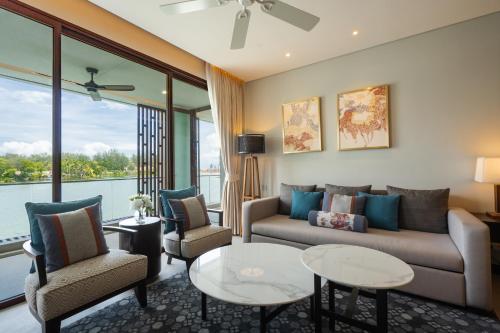 a living room with a couch and two chairs and a table at ANGSANA Oceanview apartments with jacuzzi in Laguna area in Bang Tao Beach