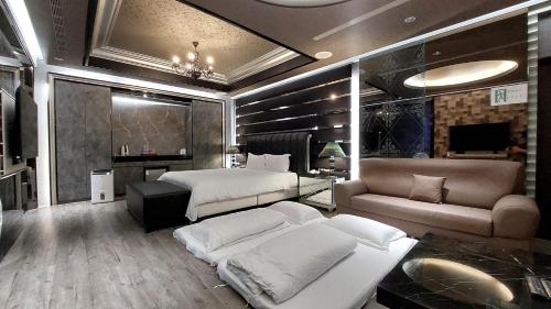 a large bedroom with two beds and a couch at Elysees Motel in Toufen