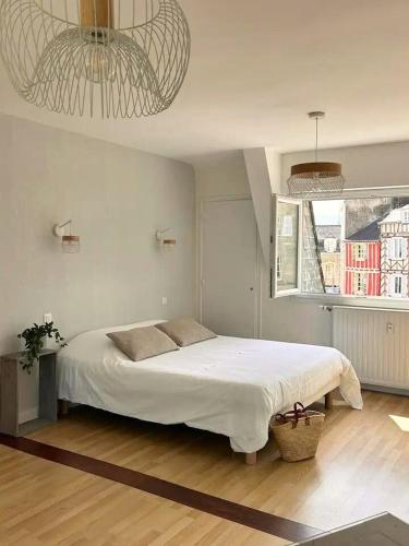 une chambre avec un grand lit blanc et une fenêtre dans l'établissement LAROCHE Grand duplex dans le centre historique avec garage, à Vannes