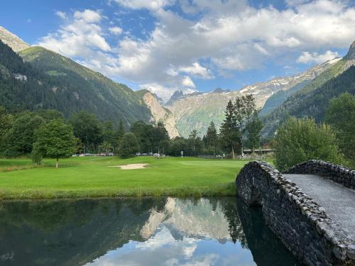 a golf course in the mountains with a reflection in the water at Hotel Hahnenblick in Engelberg