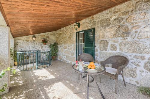 a patio with a table and chairs and a stone wall at Authentic apartment in rural area in Pindo
