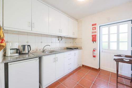 a kitchen with white cabinets and a sink at Authentic apartment in rural area in Pindo