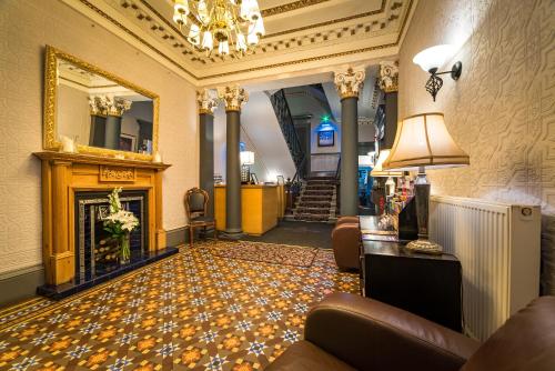 a lobby with a fireplace and a fire place at The Belhaven Hotel in Glasgow