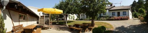 a picnic area with benches and a yellow umbrella at Haus Elstar in Bodman-Ludwigshafen
