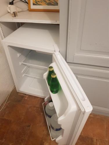 un réfrigérateur ouvert avec une bouteille verte à l'intérieur dans l'établissement Chambre indépendante au calme, au Beausset