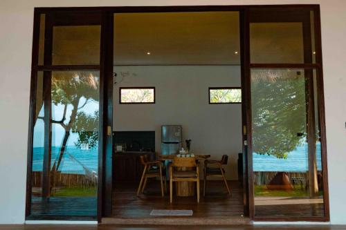 a dining room with glass doors and a table at Treeland villa in Nusa Penida